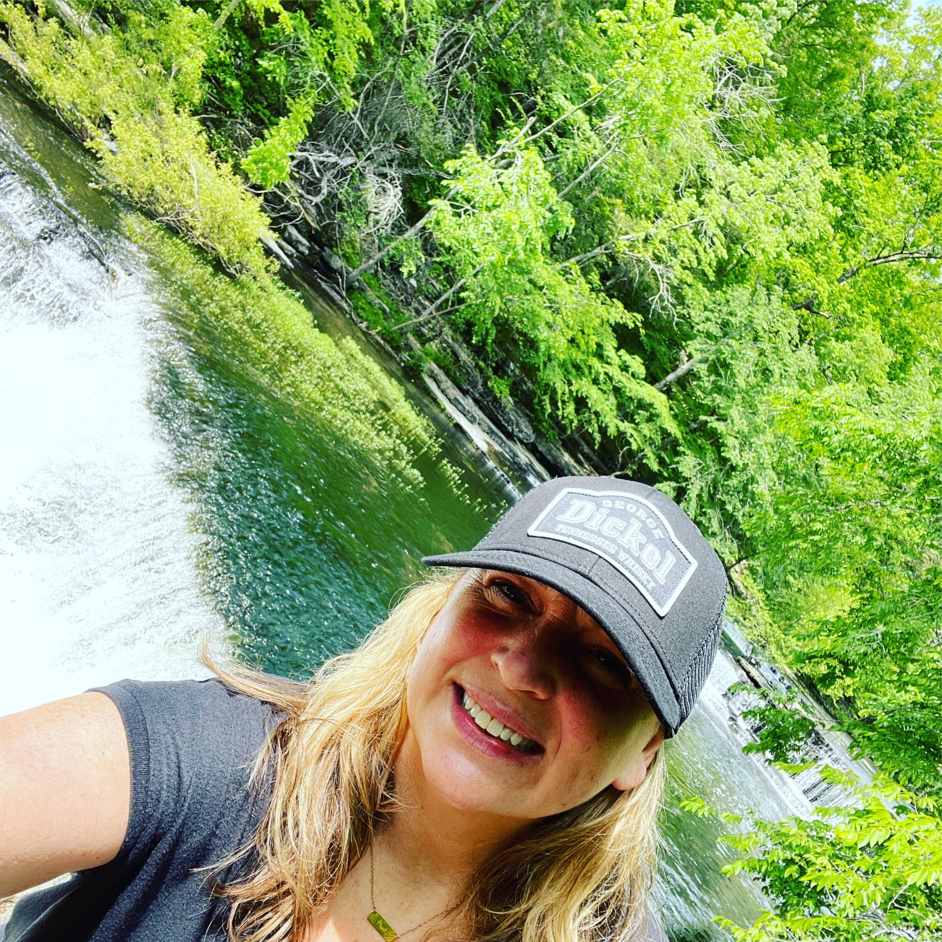 Phalynn smiling in front of a waterfall
